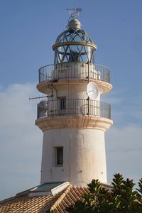 Lighthouse by sea against sky