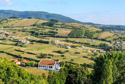 Scenic view of agricultural landscape and houses against clear sky