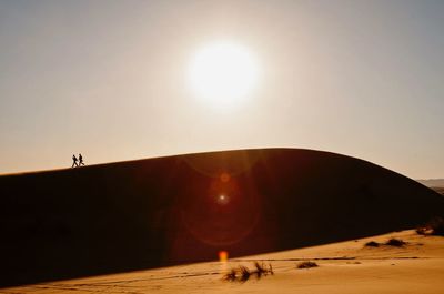 People running on sand dune