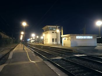 Illuminated railroad tracks in city at night