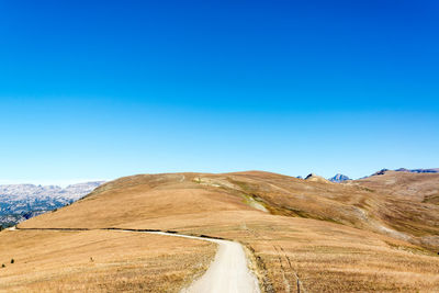 Scenic view of mountains against clear blue sky