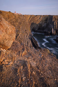 Rock formation on beach against sky