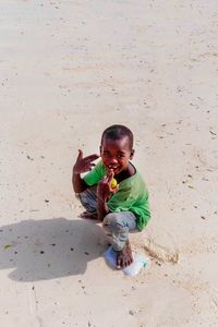 High angle view of cute boy toy on sand