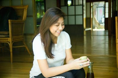 Portrait of young woman sitting on wall