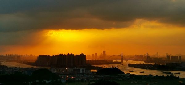 High angle view of silhouette buildings against sky during sunset