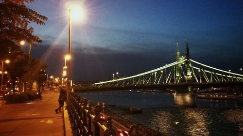 Suspension bridge over river at night