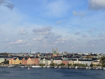 Buildings by sea against sky
