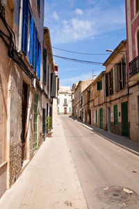 Empty road amidst buildings in town, mallorca 