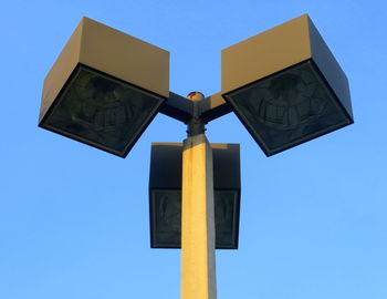 Low angle view of cross sign against clear blue sky