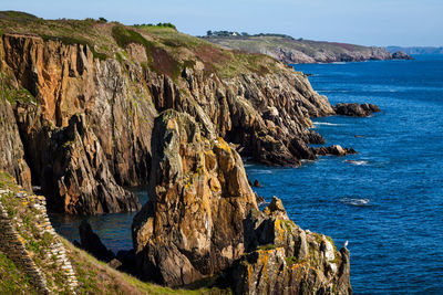 Rock formations by sea against sky