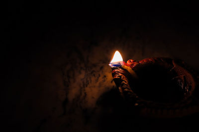 Close-up of lit candle in the dark