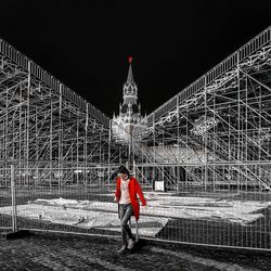 Rear view of man with umbrella standing at night