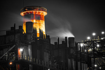 Low angle view of illuminated buildings against sky at night