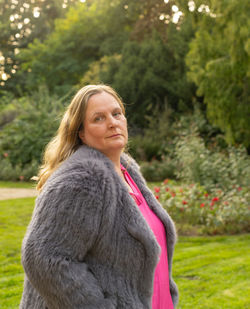 Portrait of smiling woman standing against plants