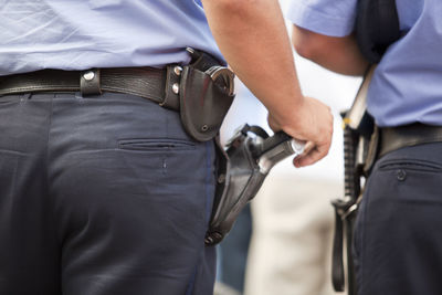 Midsection of security staff with handguns