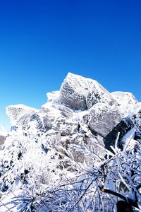 Low angle view of snow against clear blue sky