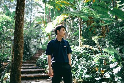 Full length of young man standing in forest