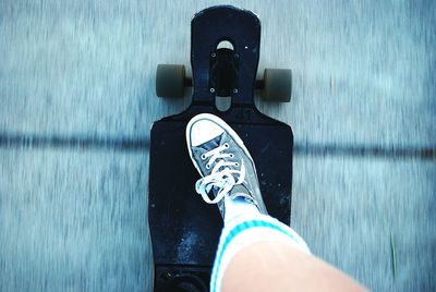 Low section of person skateboarding on road