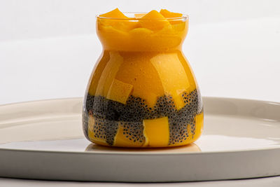 Close-up of yellow cake on table against white background