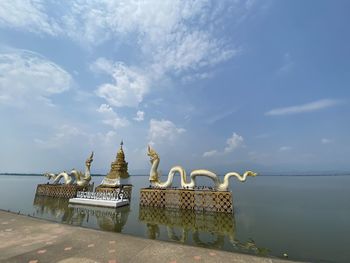 Traditional building by sea against sky