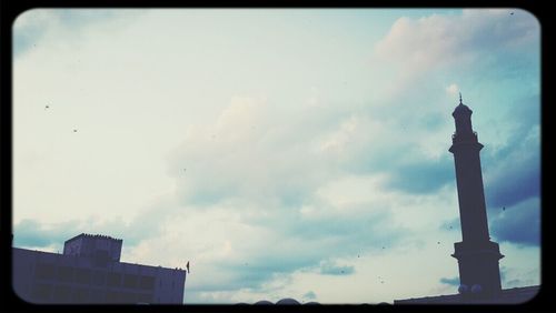 Low angle view of tower against cloudy sky