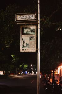 Information sign on road in city at night