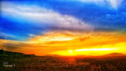 Scenic view of field against sky during sunset