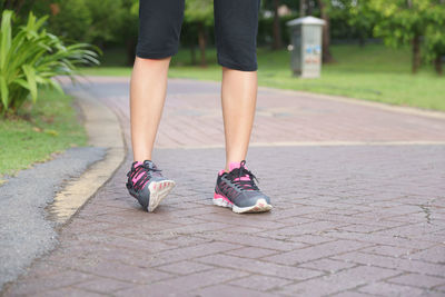 Low section of woman walking on footpath