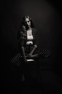 Portrait of young woman sitting in darkroom