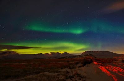 Scenic view of snowcapped mountains against sky at night