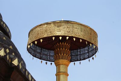 Low angle view of prayer wheel against clear sky at temple