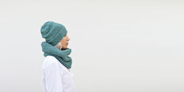 Side view of woman wearing hat against white background