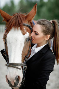 Close-up of young woman with horse