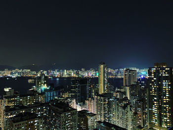 Illuminated buildings in city against sky at night