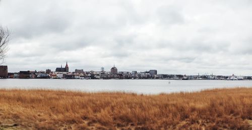 View of cityscape against cloudy sky