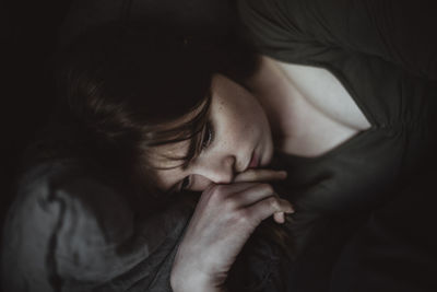 Close-up of sad woman lying on bed