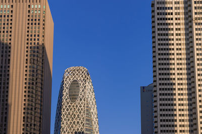 Low angle view of modern buildings against clear blue sky