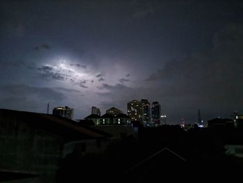 Illuminated cityscape against sky at dusk