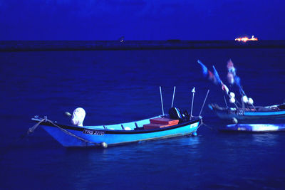 Boat moored in sea against blue sky