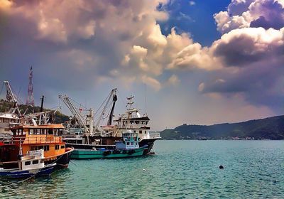 Boats in harbor against sky