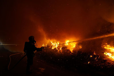 Silhouette of man with fire crackers at night