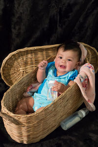 High angle portrait of cute baby boy in basket