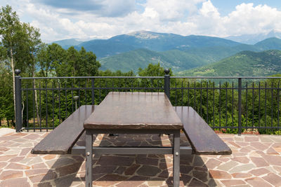 Empty chairs and table against sky