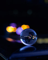 Close-up of crystal ball on table with reflection