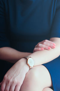 Midsection of woman in dress wearing wristwatch