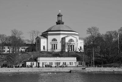 View of building by trees against clear sky