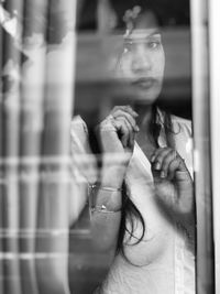 Portrait of woman seen through glass window