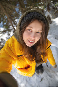 Young caucasian beautiful woman smiling. taking a selfie photo with a camera in winter, in a snowy