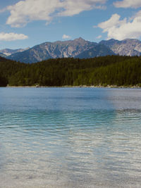 Scenic view of lake by mountains against sky