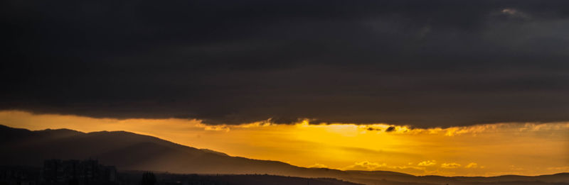 Scenic view of mountains against cloudy sky